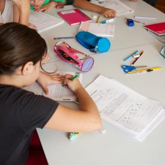 Una niña haciendo deberes en un aula.