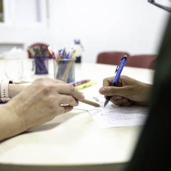 Una tècnica fent classes de reforç escolar a un menor.
