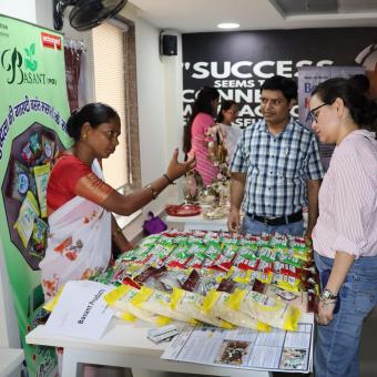 Una trabajadora miembro de BASANT vendiendo los productos que ofrece la FPO.