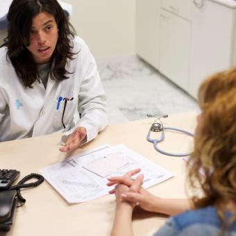 A doctor attending to a woman in her office.