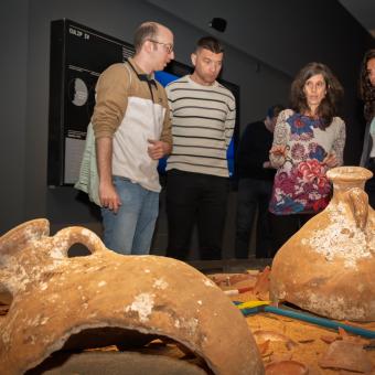 Visitants de la mostra «Naufragis. Arqueologia submergida» admirant alguns dels objectes exposats a CaixaForum Tarragona. 