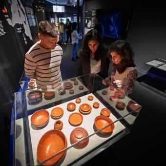 Visitants observant les obres de l'exposició «Naufragis. Arqueologia submergida» a CaixaForum Tarragona.