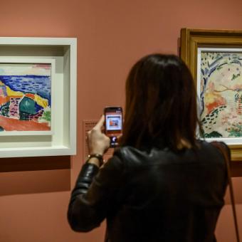 Una visitante fotografiando una de las obras presentes en la exposición Chez Matisse. El legado de una nueva pintura en CaixaForum Barcelona.