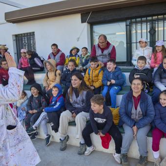 Los niños escuchan atentamente a una de las monitoras de las colonias de Semana Santa del programa CaixaProinfancia. 