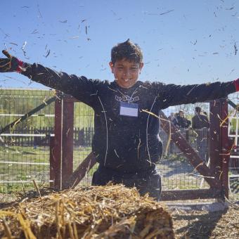 Jose jugando con la paja en un granero.