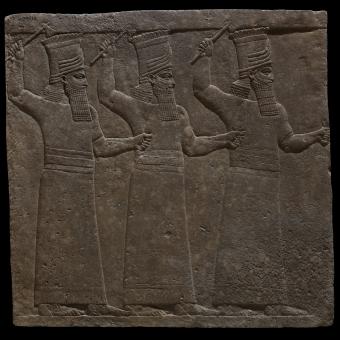 Bajorrelieve mural en yeso que representa a los dioses Sebitti y en el que todas las figuras se muestran con la mano derecha alzada sujetando un hacha, 645-64 a. de C., palacio norte, Nínive (Irak). 1856,0909.41.