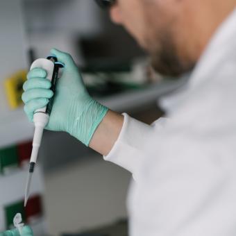 Un investigador con una micropipeta en los laboratorios del CaixaResearch Institute.