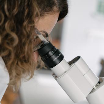 Una investigadora del CaixaResearch Institute observando muestras microscópicas en los laboratorios.