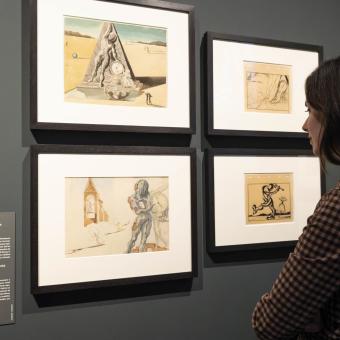Una visitante admirando los dibujos expuestos en la exposición «Los mundos de Alicia» en CaixaForum València. 