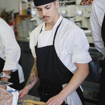 Un alumno de la escuela de cocina de Villa Retiro durante una clase.