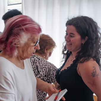 Una chica hablando con una señora mayor en el Centro Social para Personas Mayores El Llano, en Gijón. 