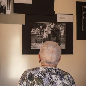 Una señora admira una fotografía antigua. 