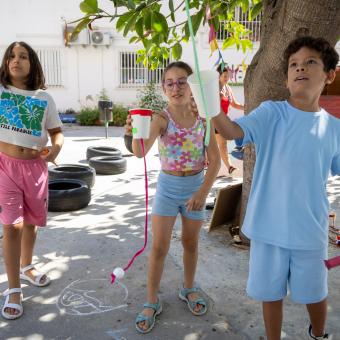 Dos niñas y un niño en una actividad de ocio educativo organizada por CaixaProinfancia.