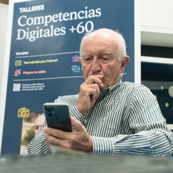 Un señor practica con el móvil durante los talleres Competencias Digitales +60.