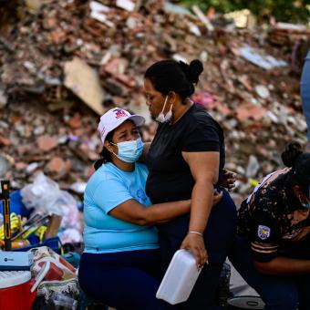 Dos mujeres se abrazan tras los terremotos en la Guaira.