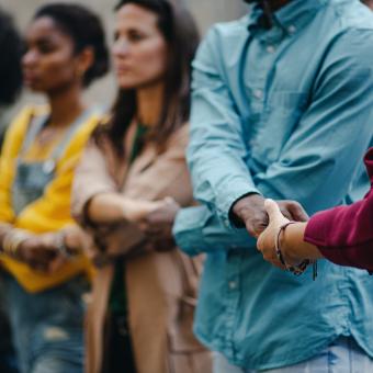 Varias personas se cogen de las manos.