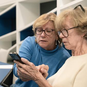 Dos personas mayores participantes en un taller de competencias digitales.