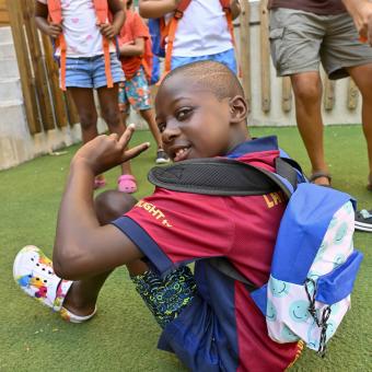 Un niño sonríe a cámara con su mochila nueva. 