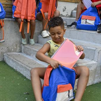 Un niño usuario del programa CaixaProinfancia con material escolar nuevo.