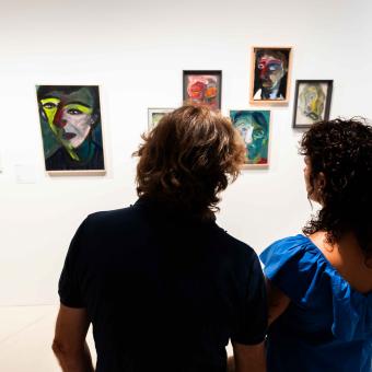 dos personas observando diversas obras expuestas en la muestra «Rumores infundados. Javier y Rafa Forteza» en CaixaForum Madrid.