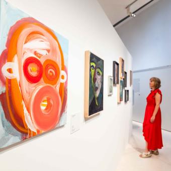 Una mujer admirando algunas de las obras expuestas en la muestra «Rumores infundados. Javier y Rafa Forteza» en CaixaForum Madrid.