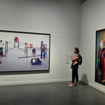 Una chica observando un cuadro de la exposición «Una fuerza del pasado» en CaixaForum Barcelona.