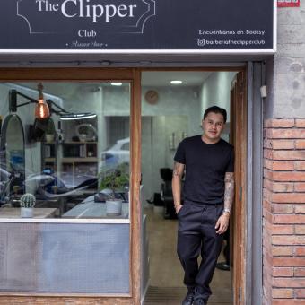 Juan Gabriel Agudelo en la entrada de su barbería, The Clipper Club, en Barcelona. 