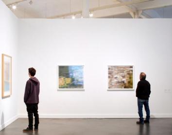 Visitantes observan las obras de una exposición en un centro CaixaForum.