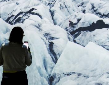 Una visitante fotografía la exposición, que contiene imágenes evocadoras.
