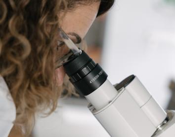 Una investigadora del CaixaResearch Institute observando muestras microscópicas en los laboratorios.