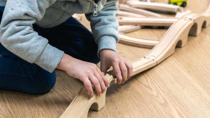 A child assembling a toy car track in the CaixaProinfancia 3-6 Growth Spaces at the Barró Association.
