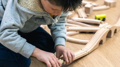 Un niño montando un circuito de coches de juguete en los Espacios de Crecimiento 3-6 de CaixaProinfancia en la Asociación Barró. 