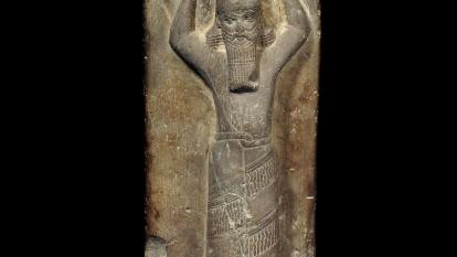 Estela de arenisca roja, con Asurbanipal transportando una cesta ritual de tierra sobre la cabeza para la reconstrucción de E-Zida, 668-655 a. de. C., templo de Nabu, Borsippa (Irak). 1880,0617.2.