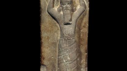 Red sandstone stela of Ashurbanipal carrying a ritual basket of earth on his head for rebuilding of E-Zida, 668-655 BC, Iraq, Borsippa, Temple of Nabu. 1880,0617.2.