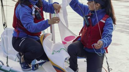 Dos chicas del programa ESFUERZA de la Fundación María José Jove preparando el barco de vela para salir a navegar.