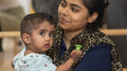 A mother holds her child in her arms.