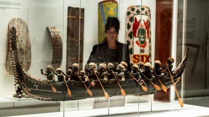 A woman closely observing one of the works in the "Voices of the Pacific" exhibition at CaixaForum Madrid.