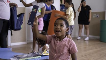 El hijo pequeño de Estefanía descubriendo el kit de material escolar entregado.