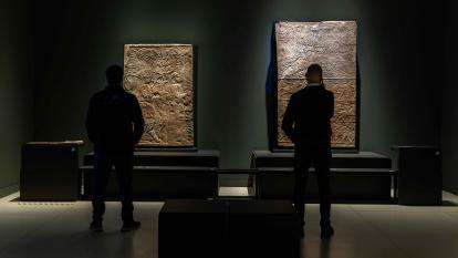 Dos visitantes admirando las obras expuestas en la exposición «Asurbanipal» en CaixaForum Madrid. 