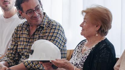 Un asistente hablando con una señora durante el encuentro intergeneracional en el Centro Social para Personas Mayores El Llano, en Gijón.