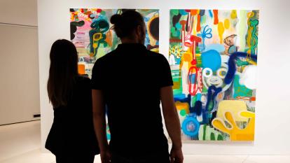 dos personas observando algunas de las obras expuestas en la muestra «Rumores infundados. Javier y Rafa Forteza» en CaixaForum Madrid.