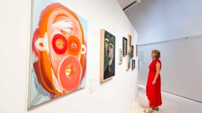 Una mujer admirando algunas de las obras expuestas en la muestra «Rumores infundados. Javier y Rafa Forteza» en CaixaForum Madrid.