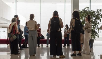 Un grup de persones cuidadores al hall de CaixaForum Barcelona.