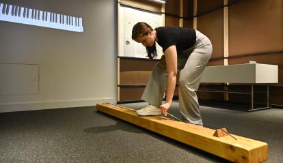 A visitor plays the monochord at the exhibition.