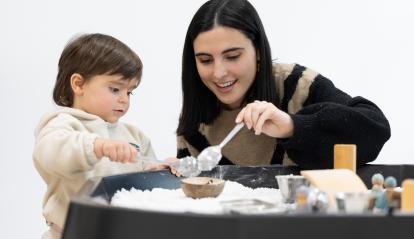 Una mare usuària del programa CaixaProinfància de la Fundació ”la Caixa” cuinant amb la filla.