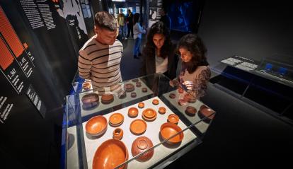 Visitants observant les obres de l'exposició «Naufragis. Arqueologia submergida» a CaixaForum Tarragona.