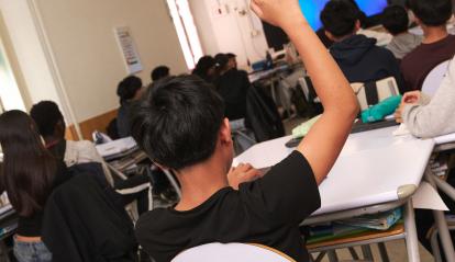 Alumno participando activamente en clase.