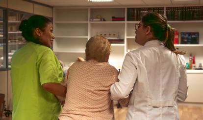 Dues treballadores de la unitat de cures pal·liatives San Camilo de Tres Cantos (Madrid) ajudant una pacient.