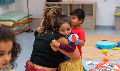 Una niña abrazando a una de las educadoras de CaixaProinfancia en la entidad Gazteleku de Bilbao.