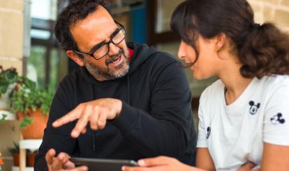 El director del CEIP Ramón y Cajal de Alpartir hablando con una alumna del centro. 